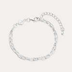 The Mini Paperclip Double Chain Bracelet in Sterling Silver features two contrasting chain styles—small and elongated links—an adjustable clasp, and a petite hexagonal charm.