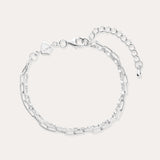 The Mini Paperclip Double Chain Bracelet in Sterling Silver features two contrasting chain styles—small and elongated links—an adjustable clasp, and a petite hexagonal charm.