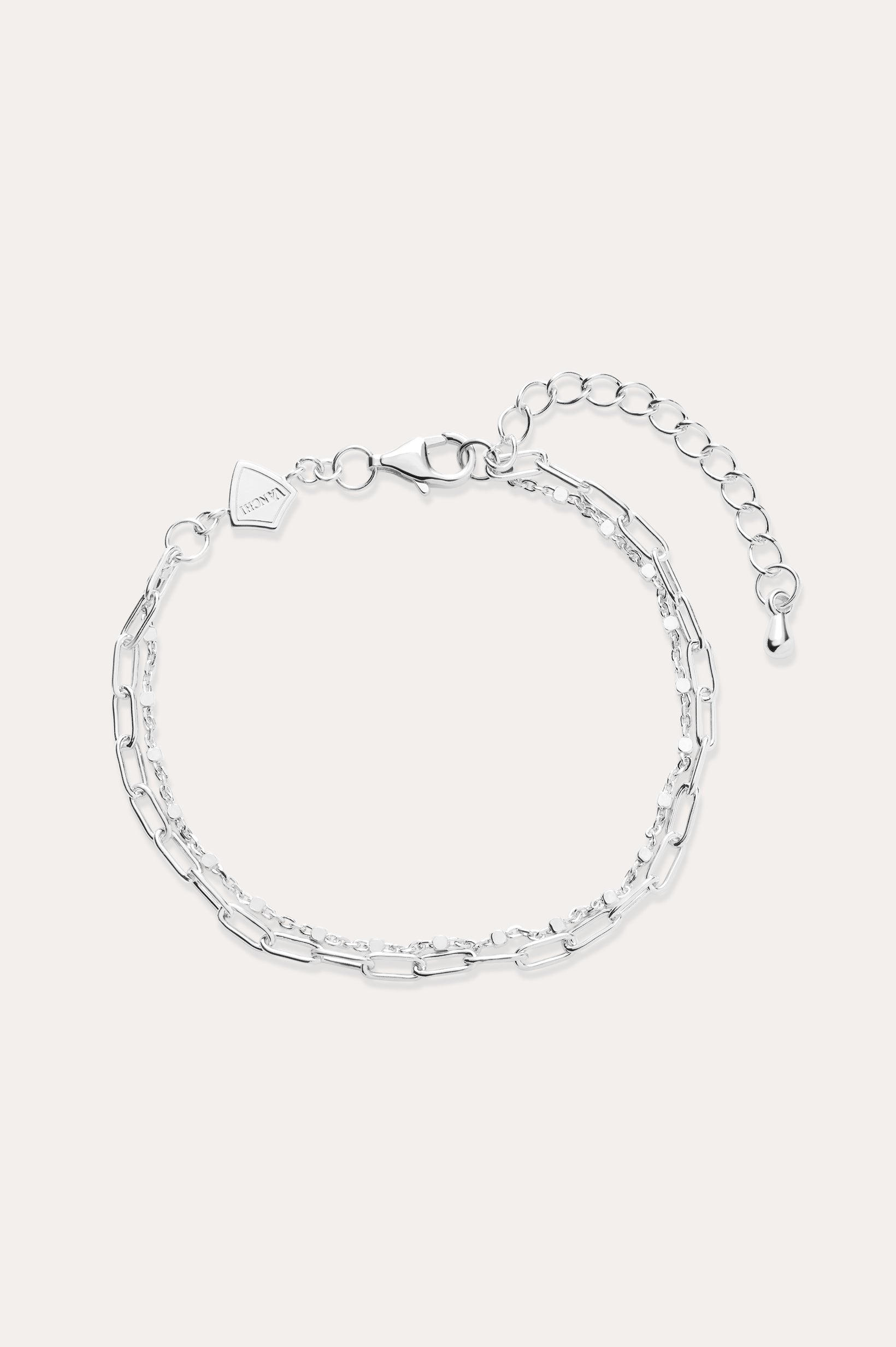 The Mini Paperclip Double Chain Bracelet in Sterling Silver features two contrasting chain styles—small and elongated links—an adjustable clasp, and a petite hexagonal charm.
