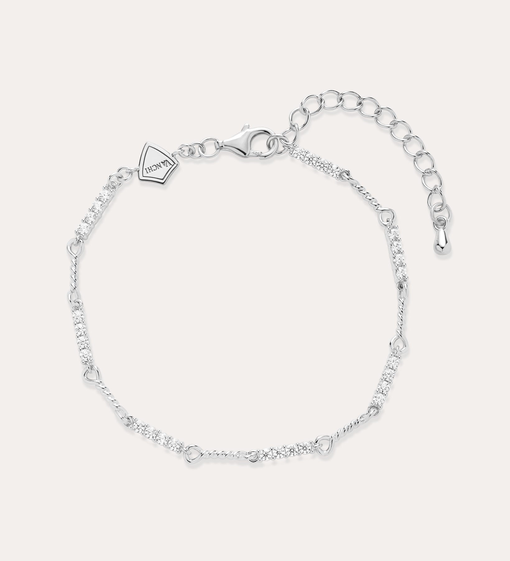 The Pia Crystal Link Bracelet in Sterling Silver features a twist chain with small clear crystals, an adjustable extension, a lobster clasp, and a heart-shaped charm near the clasp.