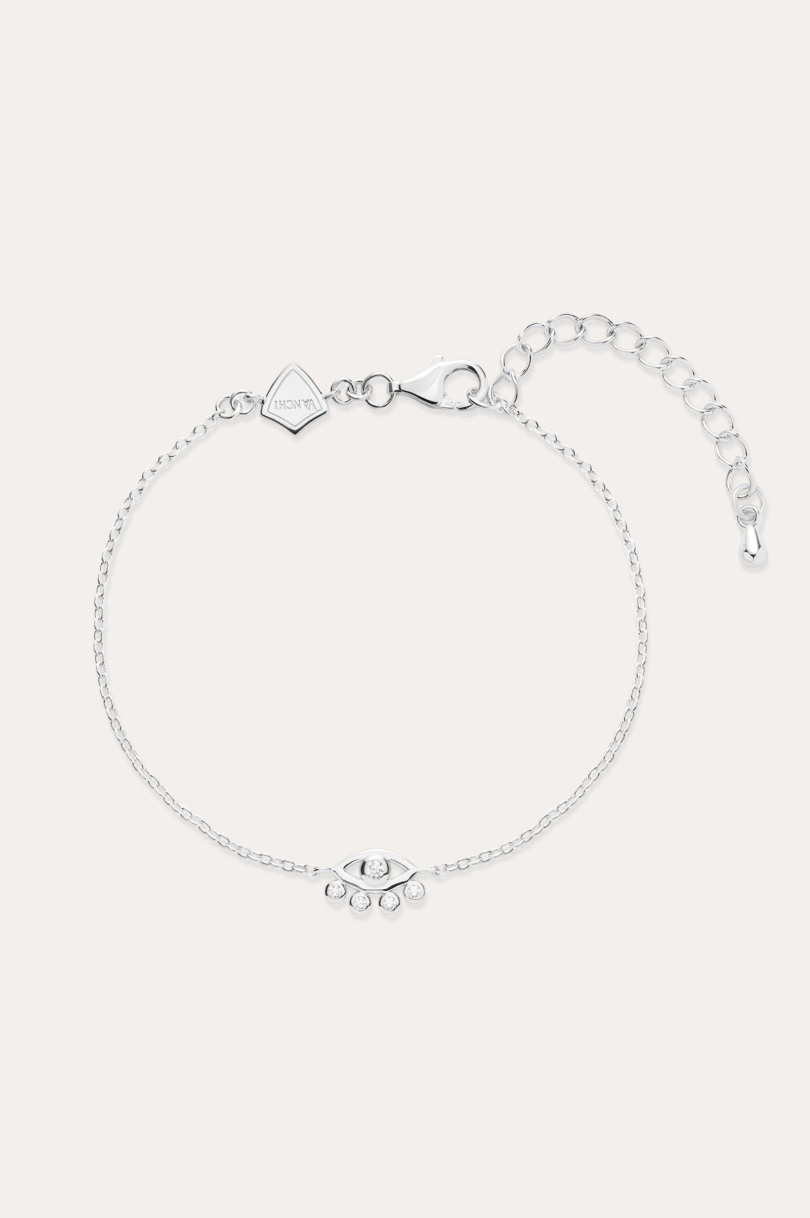 The Defender Evil Eye Bracelet in Sterling Silver features a central charm with clear cubic zirconia, an adjustable extension chain, lobster clasp, and a small square tag near the clasp.