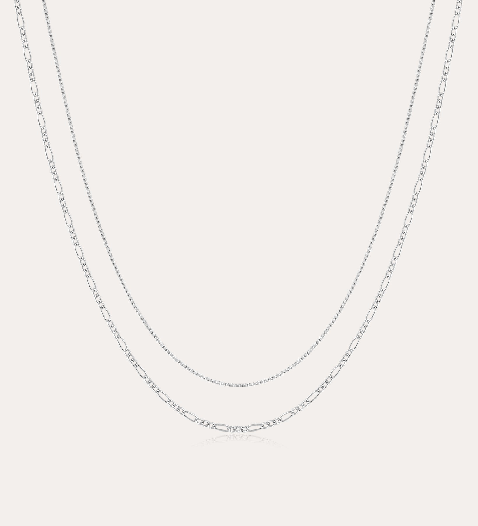 The Figaro And Box Chain Layered Necklace in Sterling Silver features a fine box chain and a longer Figaro link, both displayed against a plain white background for an elegant layered look.