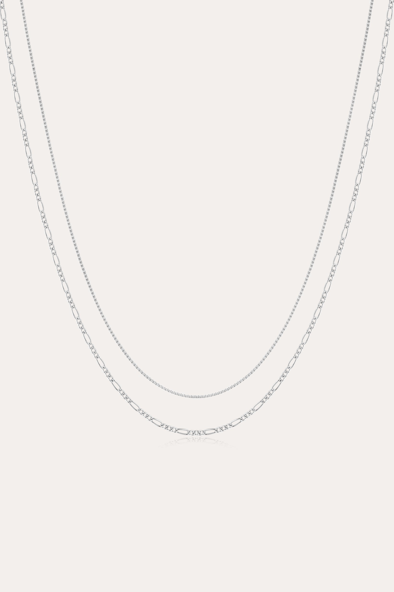 The Figaro And Box Chain Layered Necklace in Sterling Silver features a fine box chain and a longer Figaro link, both displayed against a plain white background for an elegant layered look.