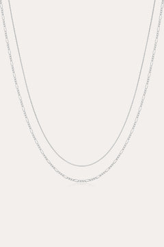 The Figaro And Box Chain Layered Necklace in Sterling Silver features a fine box chain and a longer Figaro link, both displayed against a plain white background for an elegant layered look.