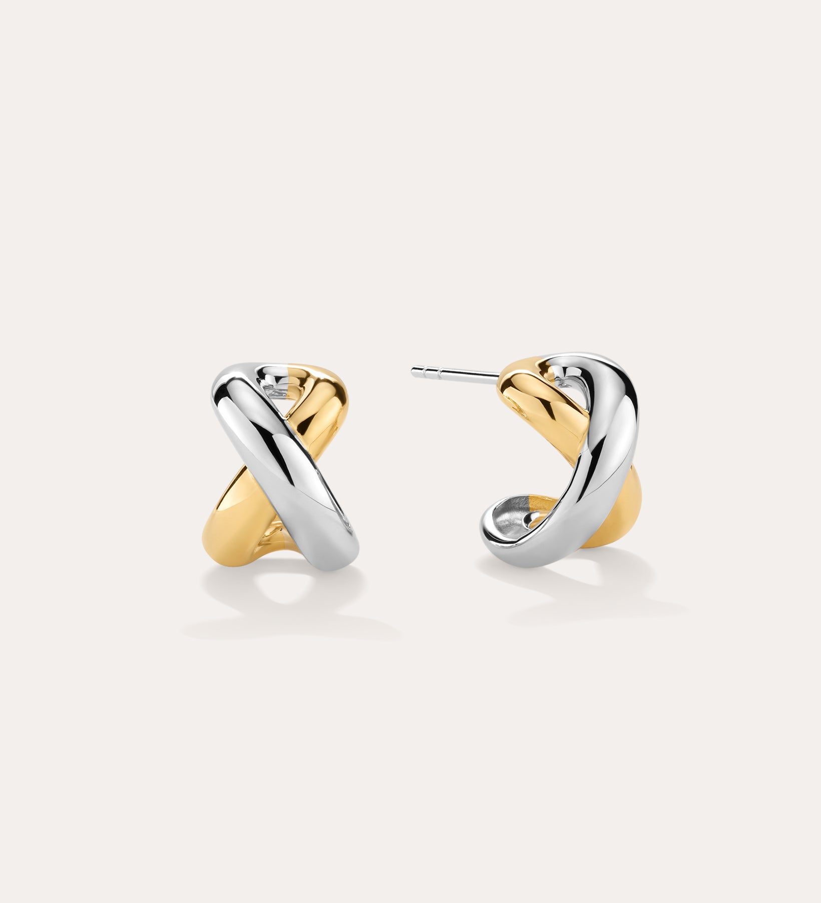Mia Two-tone Mixed Metal Hoops in 18k gold plating feature an intertwined gold and silver design, shown on a light background—ideal for everyday wear.
