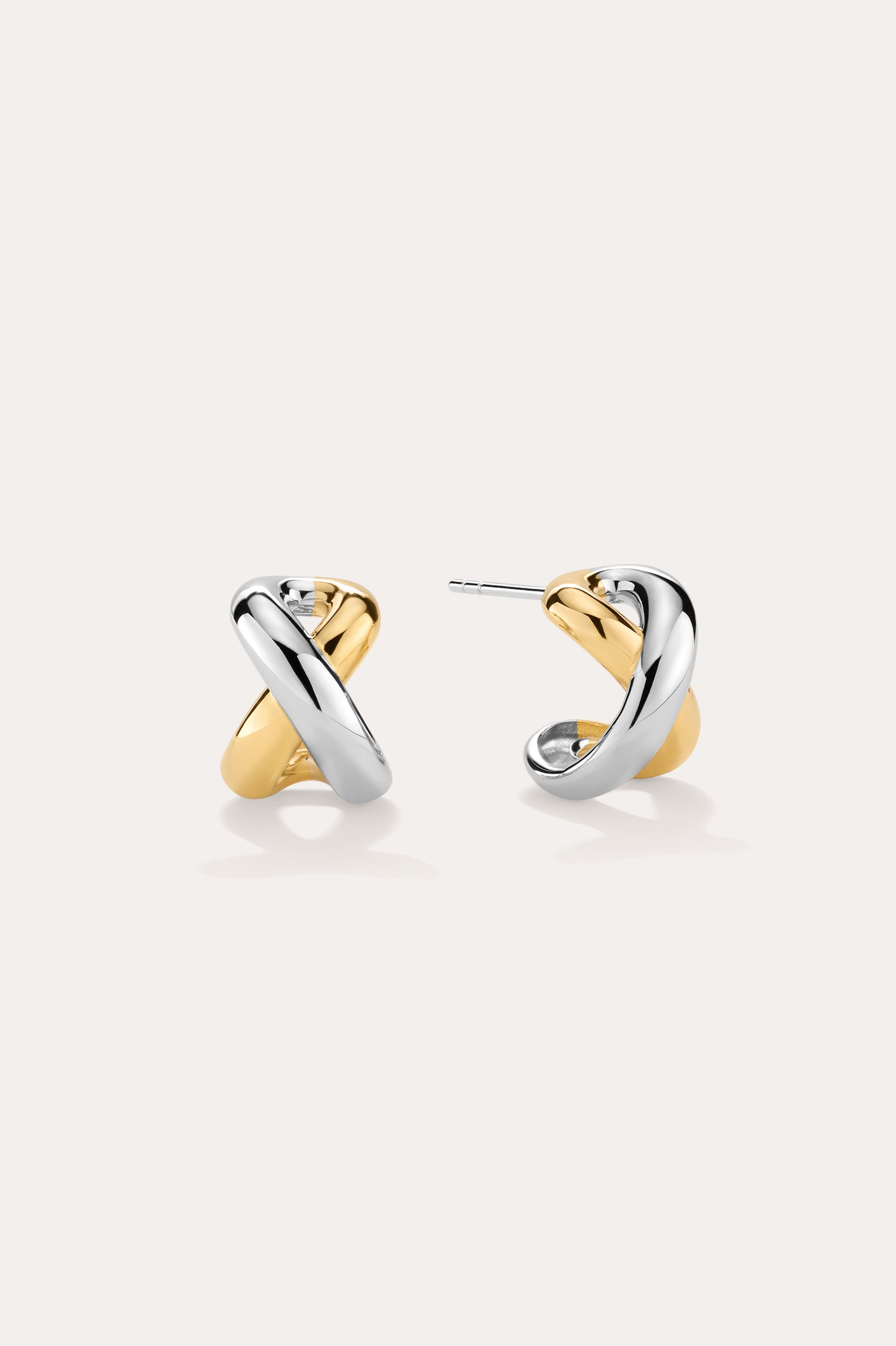 Mia Two-tone Mixed Metal Hoops in 18k gold plating feature an intertwined gold and silver design, shown on a light background—ideal for everyday wear.