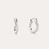 The Nori Mini Twisted Huggies in Sterling Silver feature a sculptural twisted hoop design and are shown against a light, plain background.