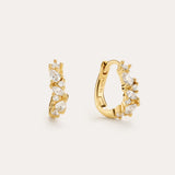 The Nori Twisted Crystal Huggies in Silver, plated in 18k gold, feature a clustered arrangement of marquise and round-cut cubic zirconia—perfect gold earrings to add sparkle to any look. Displayed against a light background.