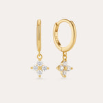 The Flora Crystal Charm Huggies in Gold are 18k gold plated earrings with dangling floral-shaped pendants of five clear gemstones. Shown from both front and side, they display their elegant shine and secure clasp beautifully.