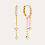 The Star Double Chain Dangle Huggies in Gold feature 18k gold plating with two star-shaped charms on each chain drop and sparkling cubic zirconia for an elegant, delicate look.