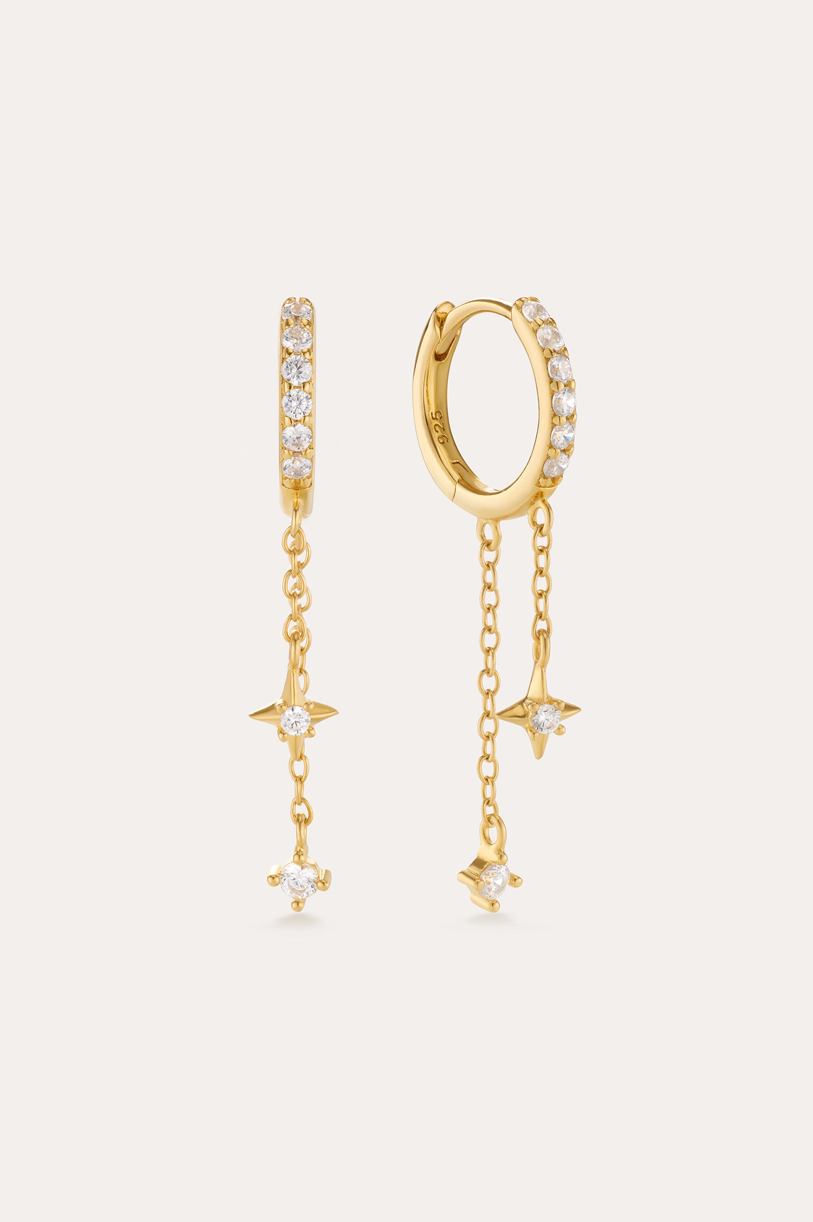 The Star Double Chain Dangle Huggies in Gold feature 18k gold plating with two star-shaped charms on each chain drop and sparkling cubic zirconia for an elegant, delicate look.