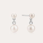 The Double Freshwater Pearl Drop Stud Earrings in Silver feature two lustrous freshwater pearls on each sterling silver stud, designed with a minimalist touch and a radiant finish.