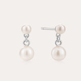 The Double Freshwater Pearl Drop Stud Earrings in Silver feature two lustrous freshwater pearls on each sterling silver stud, designed with a minimalist touch and a radiant finish.
