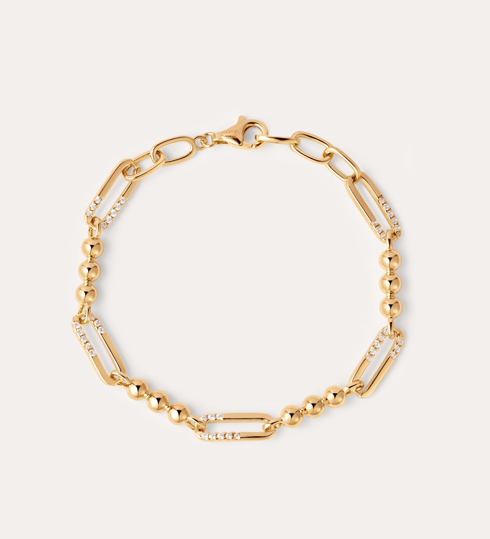 The Carly Paperclip Chain Bead Bracelet in Gold features alternating large 18k gold plated links, some adorned with sparkling cubic zirconia and sections of round gold beads, finished with a lobster clasp.