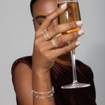 Person holding a glass of champagne with a neutral background