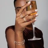 Person holding a glass of champagne with a neutral background