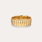 The Charlotte Eternity Ridged Ring in Gold features a scalloped, ribbed design encircling the band, elegantly displayed against a plain, light background.