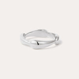 The Colette Link Droop Ring in Silver features a minimalist design with a smooth, slightly irregular band and rounded ends, shown against a light background.