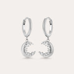 Crescent Moon Crystal Charm Huggies in Silver feature dangling crescent moon charms with sparkling cubic zirconia, shown on a light background.