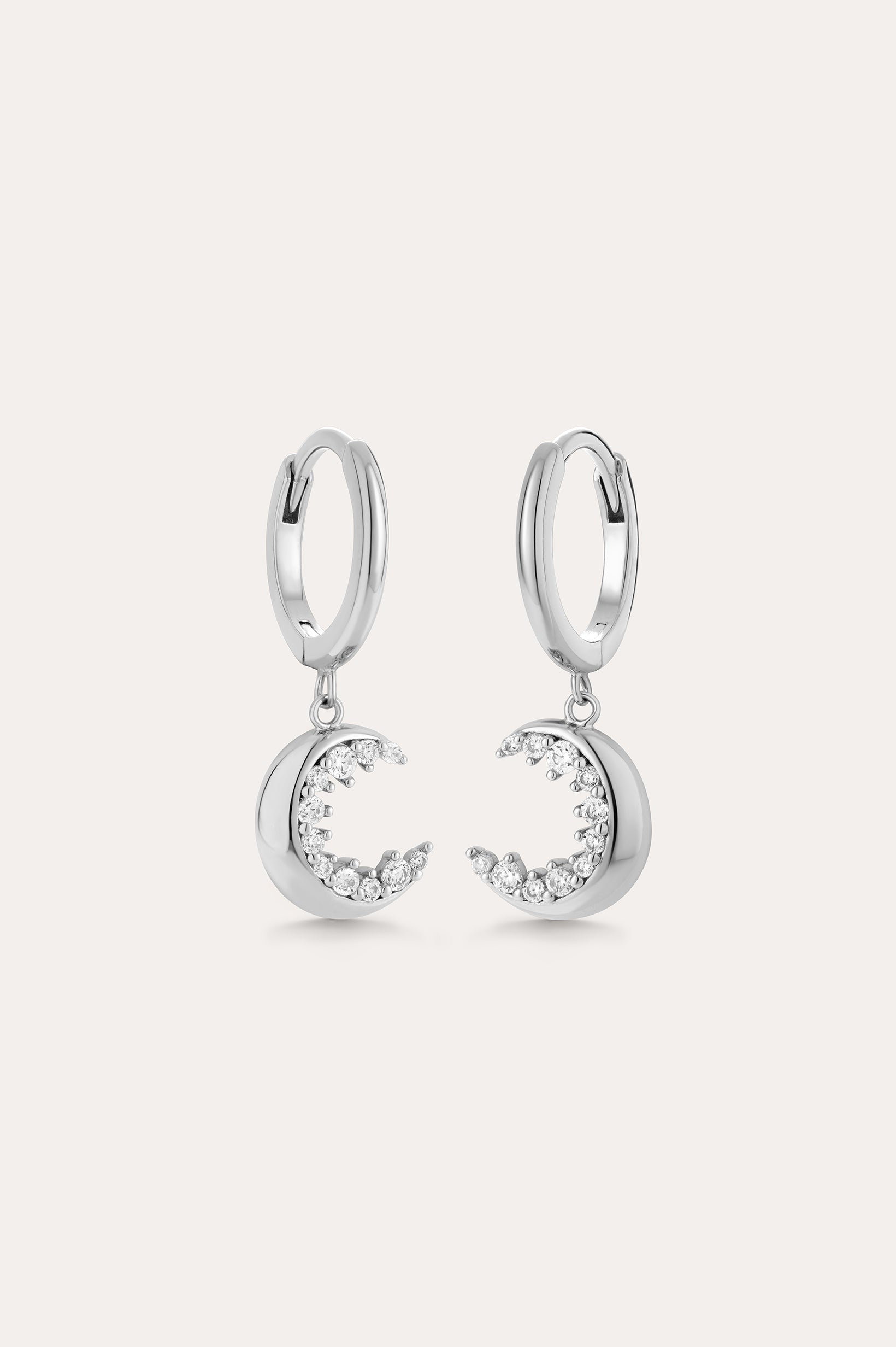Crescent Moon Crystal Charm Huggies in Silver feature dangling crescent moon charms with sparkling cubic zirconia, shown on a light background.