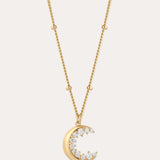 The Crescent Moon Crystal Charm Beaded Necklace in Gold features a beaded chain and a crescent moon pendant with sparkling clear stones, shown against a simple light background.