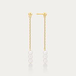 Gold chain earrings with pearls on a light gray background
