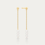 Gold chain earrings with pearls on a light gray background