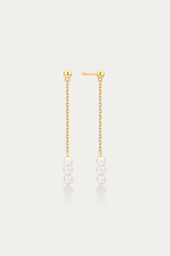 Gold chain earrings with pearls on a light gray background