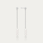 Pair of pearl drop earrings on a light gray background