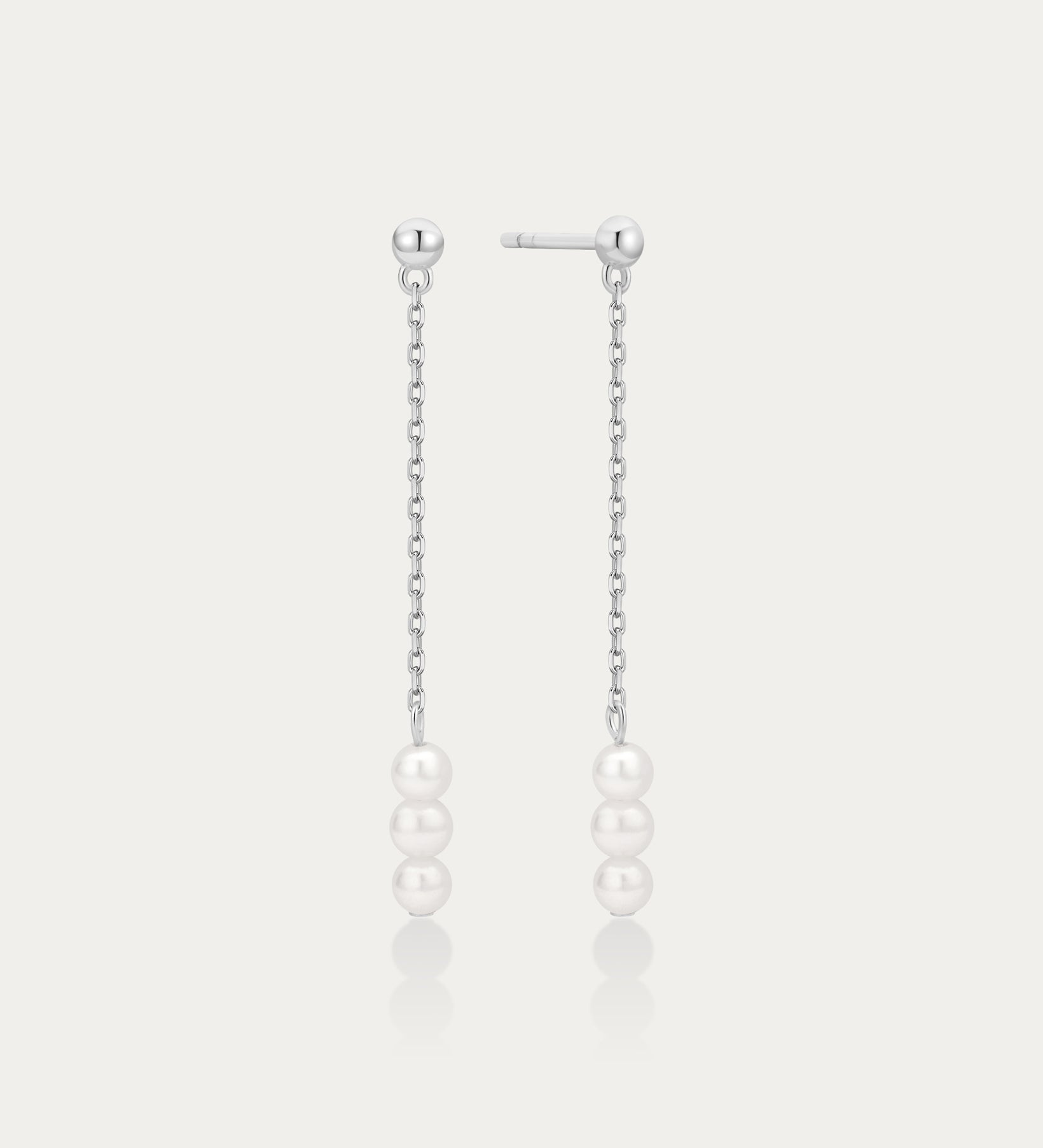 Pair of pearl drop earrings on a light gray background