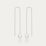The Eira Pearl Drop Threader Earrings in Silver feature elegant thin chains with a single white pearl at each end, shown on a plain white background.