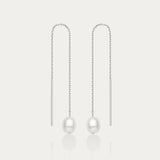 The Eira Pearl Drop Threader Earrings in Silver feature elegant thin chains with a single white pearl at each end, shown on a plain white background.
