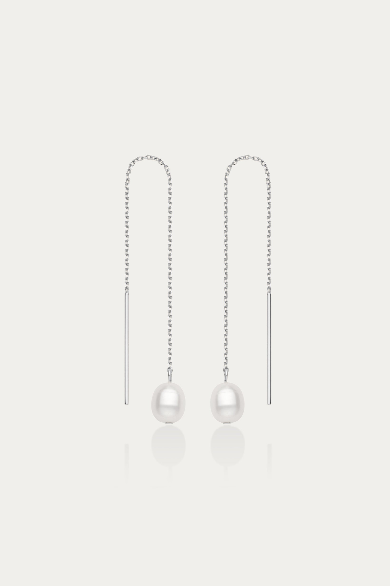 The Eira Pearl Drop Threader Earrings in Silver feature elegant thin chains with a single white pearl at each end, shown on a plain white background.