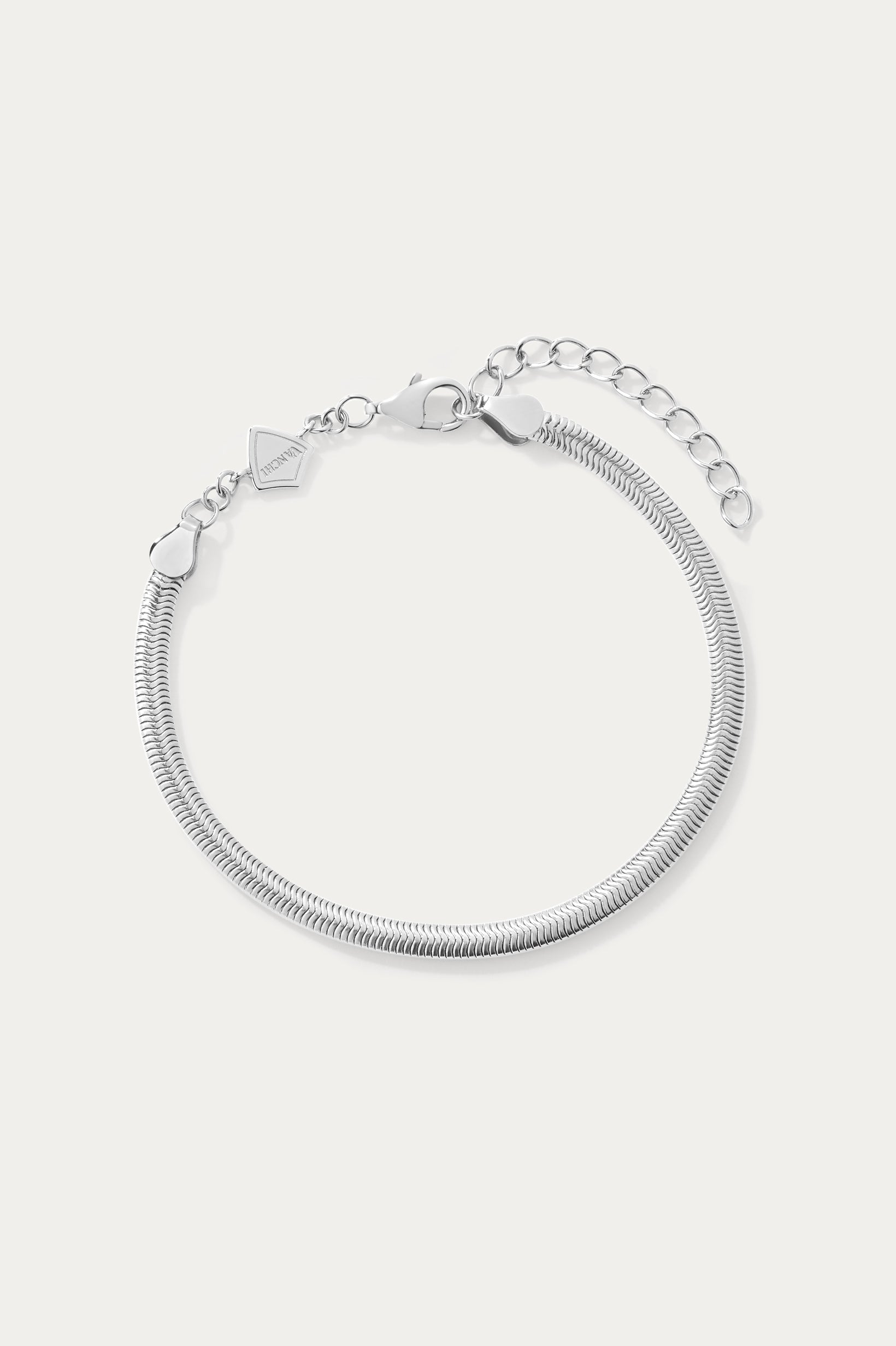The Estelle Herringbone Chain Bracelet in Silver features a 3mm sleek chain, an adjustable extension, and a small charm by the clasp, shown against a plain white background.