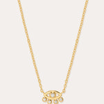 The Defender Evil Eye Necklace in Gold features an 18k gold-plated eye-shaped pendant with a central cubic zirconia and four dangling crystals, shown on a plain white background.