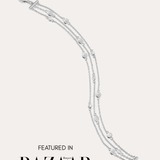 The Simone Triple Chain Layered Bracelet in Silver, featuring three delicate sterling silver chains and round accents, is displayed on a white background with the text: Featured in Harper’s Bazaar.