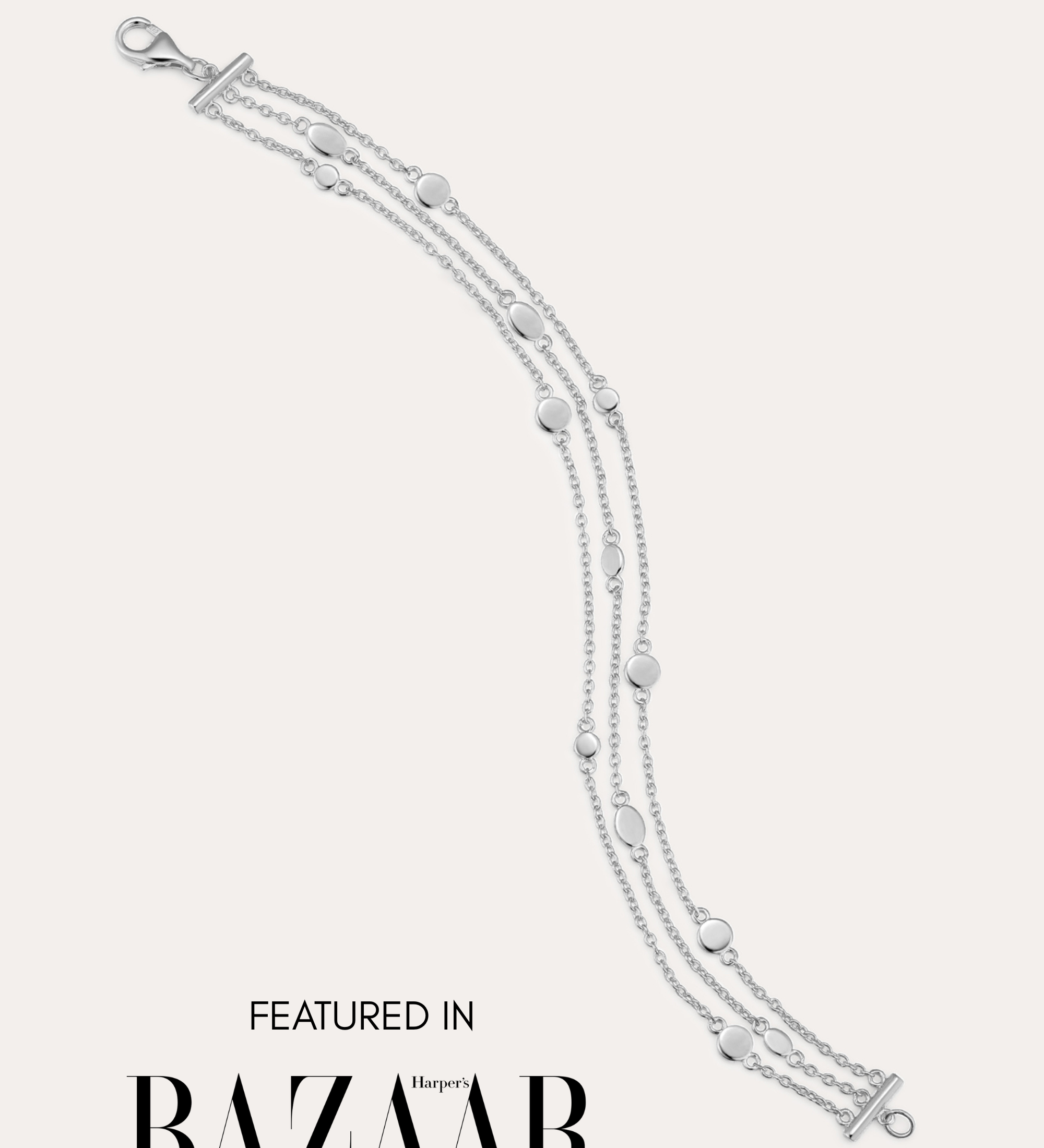 The Simone Triple Chain Layered Bracelet in Silver, featuring three delicate sterling silver chains and round accents, is displayed on a white background with the text: Featured in Harper’s Bazaar.