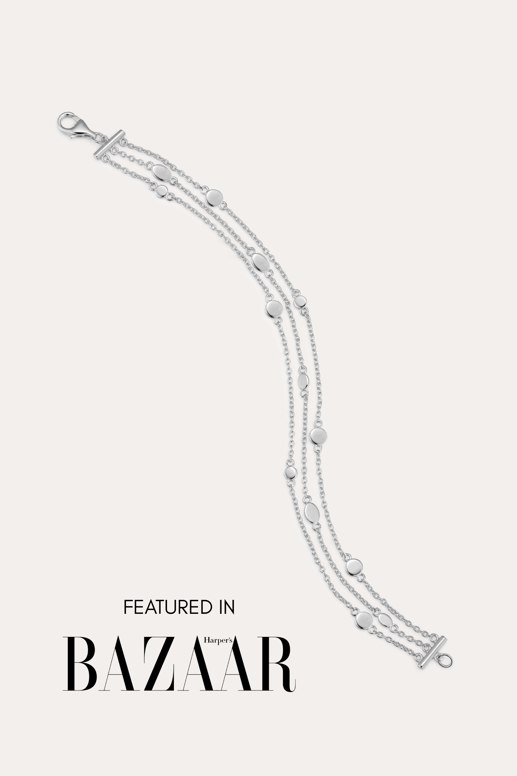 The Simone Triple Chain Layered Bracelet in Silver, featuring three delicate sterling silver chains and round accents, is displayed on a white background with the text: Featured in Harper’s Bazaar.