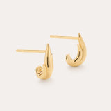 The Flame Stud Earrings in Gold are a shiny, 18k gold plated, crescent-shaped pair shown on a plain light background—one lying flat and the other upright to highlight their sculptural design and post backs.