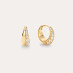 The Georgie Crystal Knife Edge Huggie Hoop Earrings in Gold feature a row of sparkling white gemstones along the front, shown against a plain light background.