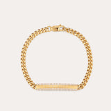 The Gisèle Cuban Link Bar Bracelet in Gold features a gold-plated chain, a lobster clasp, and a horizontal rectangular bar embellished with small sparkling clear stones.