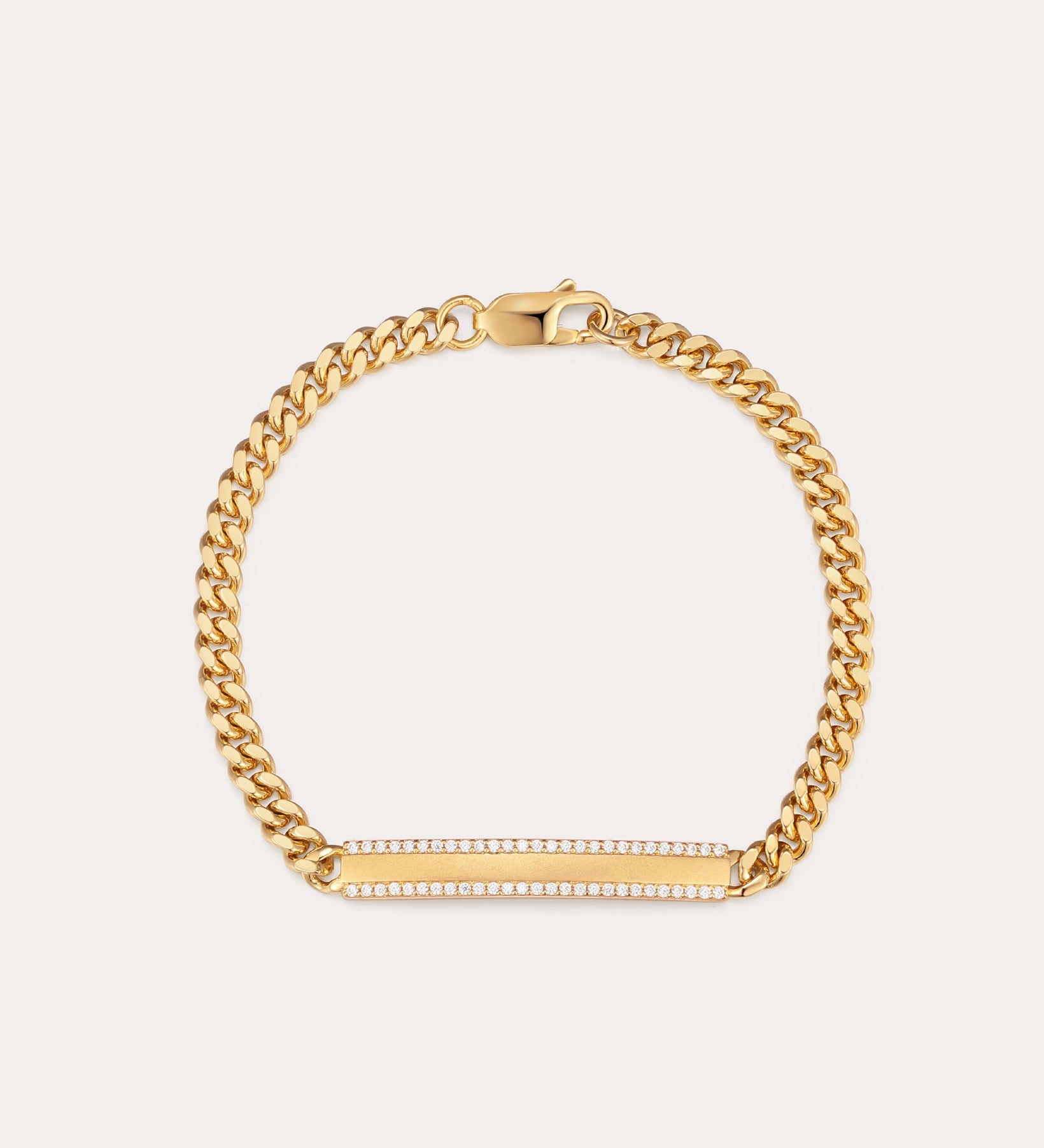 The Gisèle Cuban Link Bar Bracelet in Gold features a gold-plated chain, a lobster clasp, and a horizontal rectangular bar embellished with small sparkling clear stones.