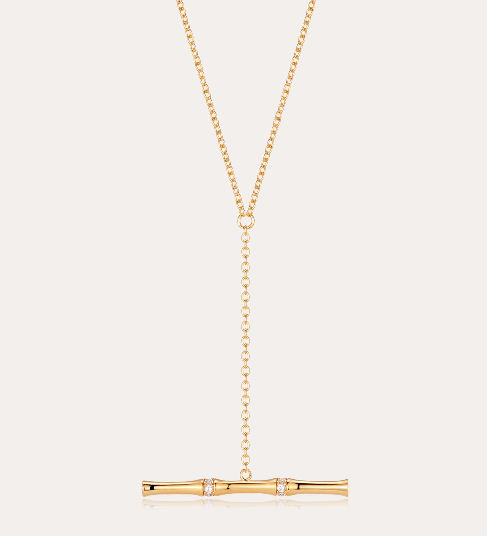 The Bamboo Chain Y-Bar Lariat Necklace in Gold features a delicate Y-shaped chain ending in a horizontal gold bar, accented with sparkling gemstones.
