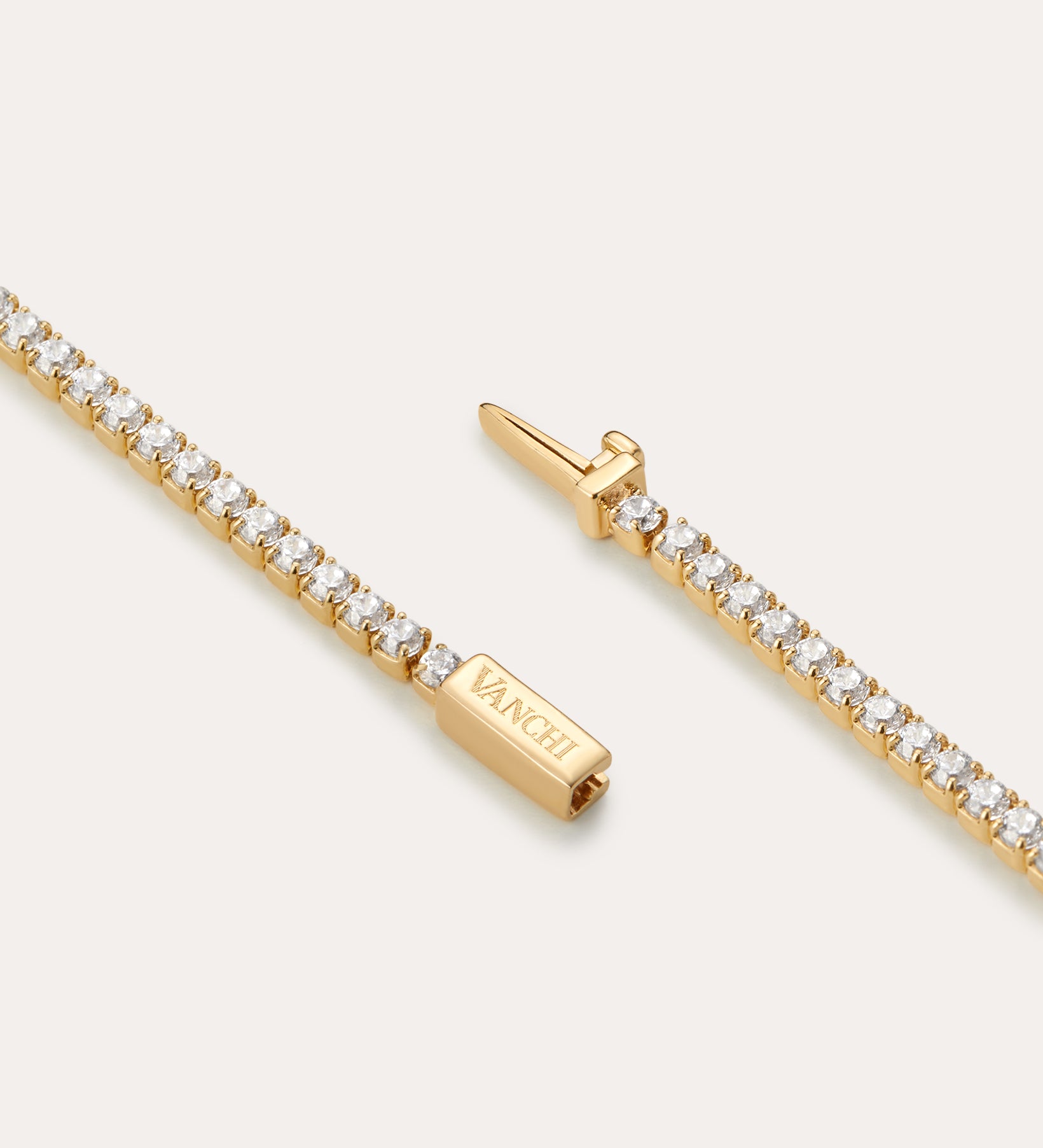 A close-up of the Lumi Tennis Bracelet in Gold shows small round white stones and a rectangular clasp engraved with VANCLI.