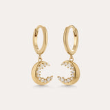 Crescent Moon Crystal Charm Huggies in Gold, featuring crescent moon charms with sparkling cubic zirconia, displayed on a plain light background.