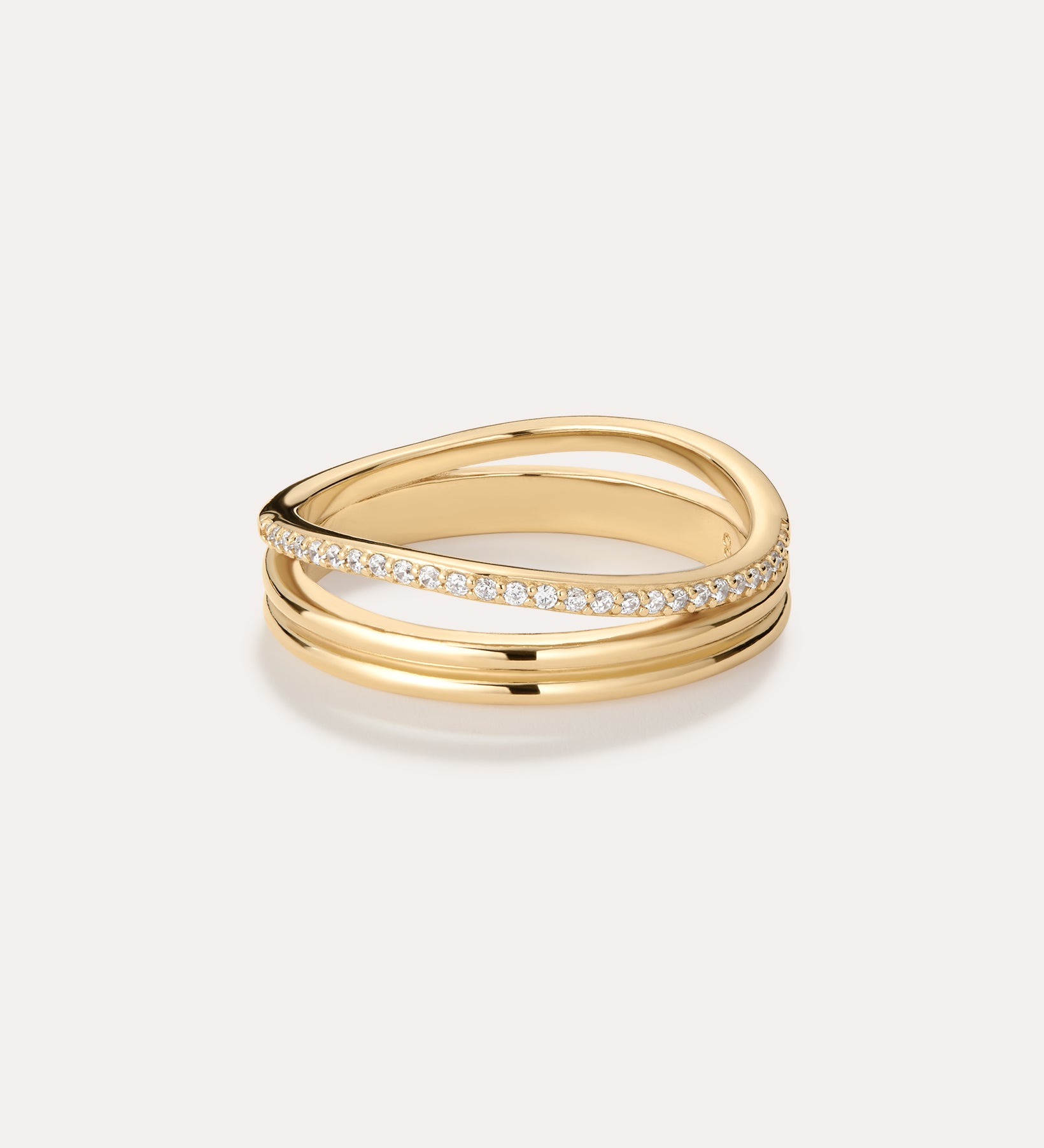 The Noor Pavé Triple Band Ring in Gold features three intertwined bands—one with pavé-set sparkling diamonds and two smooth, polished gold bands for a sophisticated look.