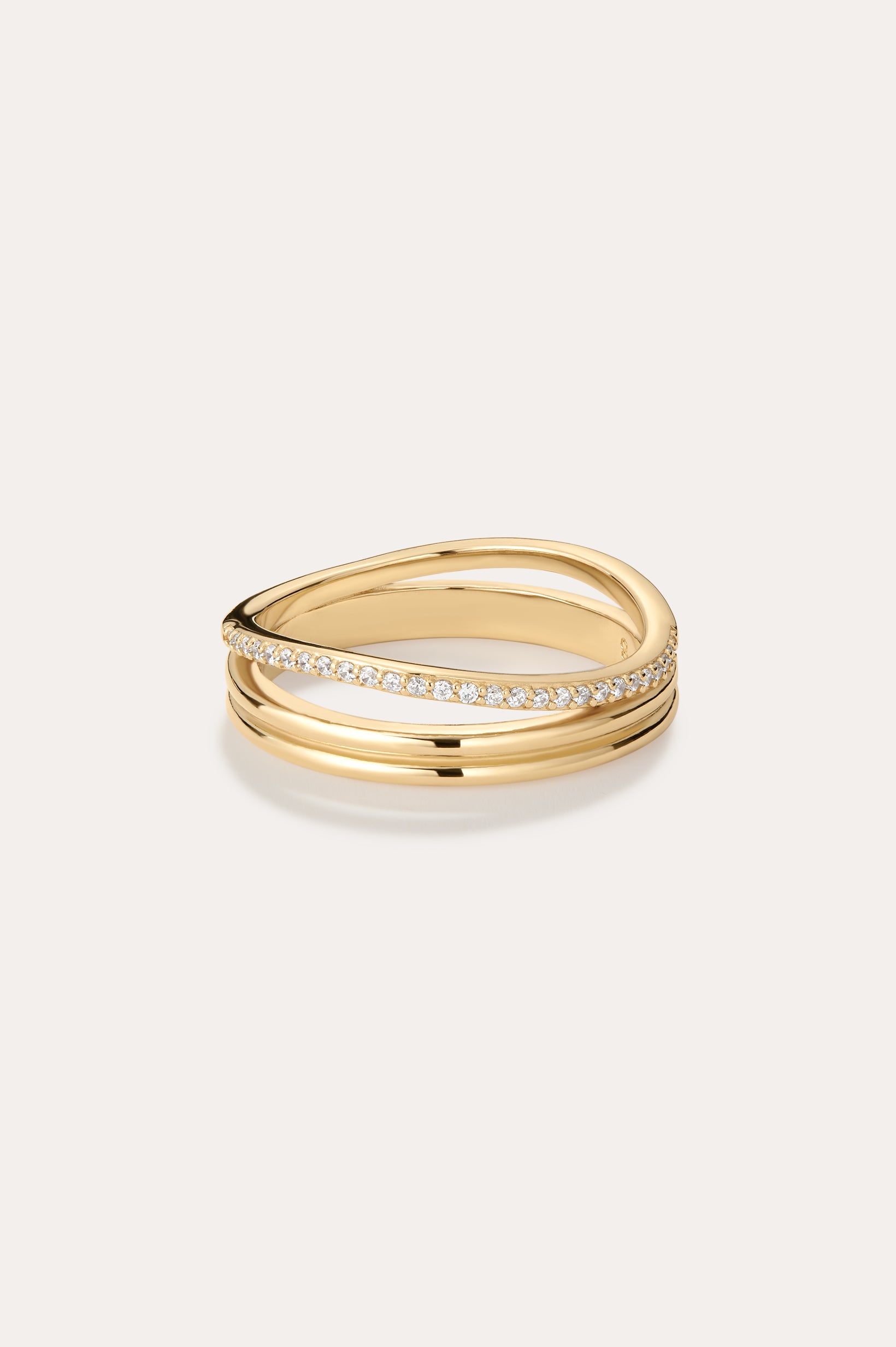 The Noor Pavé Triple Band Ring in Gold features three intertwined bands—one with pavé-set sparkling diamonds and two smooth, polished gold bands for a sophisticated look.