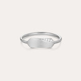 The Ines Horizontal Bar Ring in Silver features a delicate silver band with a flat geometric plate, accented by a sparkling cubic zirconia cluster on one side and finished in a subtle matte texture.