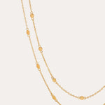 The Simona Double Chain Stacking Necklace in Gold features delicate oval-shaped accents spaced evenly along its length, ideal for stacking or layering, and is shown against a simple, light background.