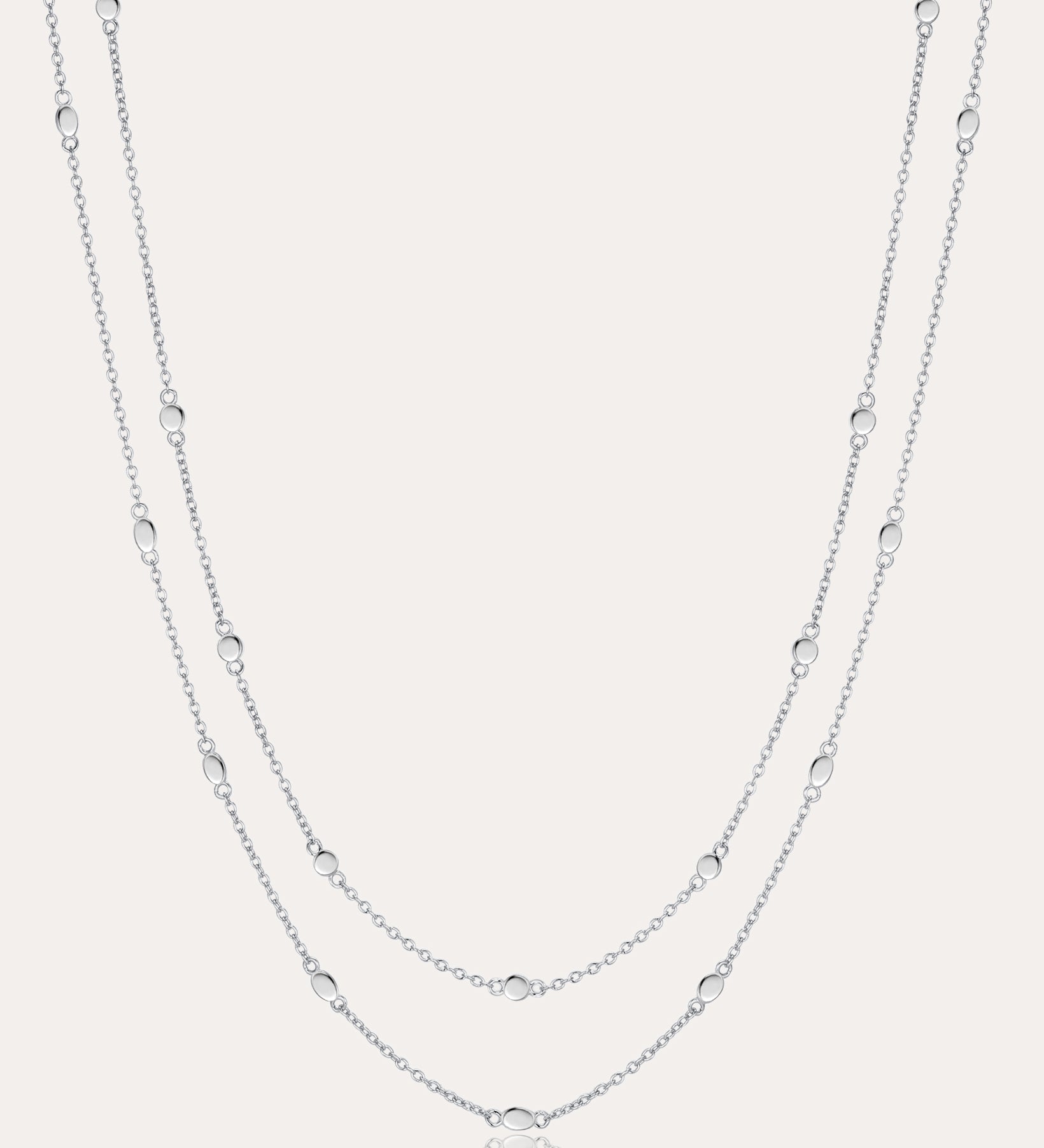 The Simona Double Chain Stacking Necklace in Silver features two delicate layers with small, evenly spaced beads along each chain, shown against a light background.